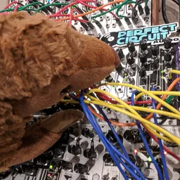 A Noise Engineering pangolin on top of a patched Eurorack system